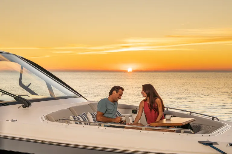 2026-Sundancer-370-Outboard-DAO370-lifestyle-couple-bow-table-sunset-05895-X4